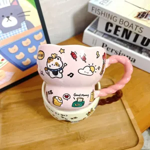 Close-up van een schattige roze keramische koffiekop met gedraaid handvat en leuke tekeningen.