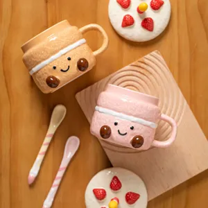 Close-up detail of cute ceramic dessert mug with face design, matching spoon and strawberry lid.
