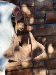 Detail van een zachte pluche schoudertas met gouden ketting voor een stijlvolle look.