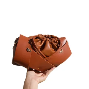 Retro brown leather crossbody bag with chic knotted straps and soft pleated pouch design.