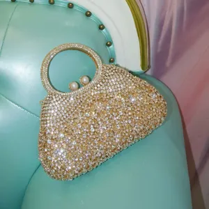 Vue de détail d'un sac de soirée luxueux en strass étincelant avec poignée ronde.