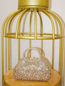 Gros plan d'un sac de soirée étincelant en strass avec des détails de cristaux et fermoir perle.