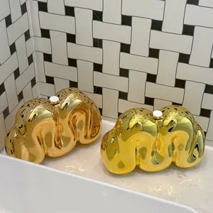 Detailansicht der kreativen goldenen Acryl-Clutch mit flüssigem Metall-Design, glänzende Tasche.