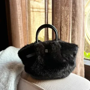 Detailansicht der schwarzen flauschigen Handtasche mit weicher Felltextur und Ledergriffen.