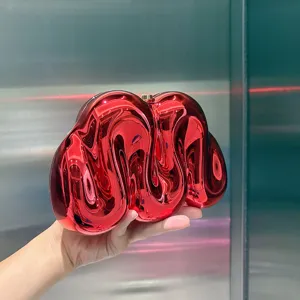 Nahaufnahme Detail der roten metallisch glänzenden unregelmäßigen Acryl Clutch Abendtasche.
