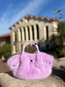 Detailansicht einer süßen flauschigen Kunstfell Handtasche in Lila mit Henkeln.