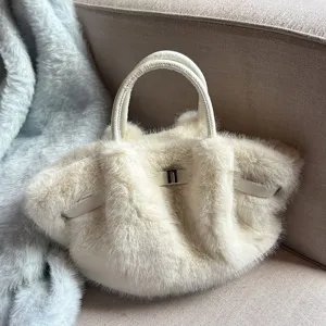Detailaufnahme der flauschigen Cremefarbigen Plüschtasche mit edlem Verschluss im Winter.