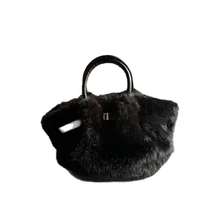 Schwarze Kunstfell Handtasche mit Henkeln und stylischem Riemenverschluss fuer Damen Mode Herbst.