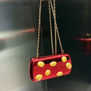 Rote metallische Clutch Tasche mit Goldkette und gelben 3D Punkten, modisches Detailbild.