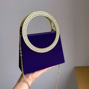 Detailansicht der lila Abendtasche mit glitzerndem Strass-Rundmetallgriff und Kettengurt.