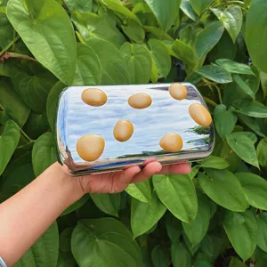 Silberne Abend-Clutch Tasche aus Metall mit unregelmäßigen bernsteinfarbenen Punkten.