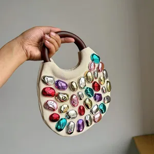 Canvas handbag featuring a round wooden handle and colorful metallic stone decorations for women.