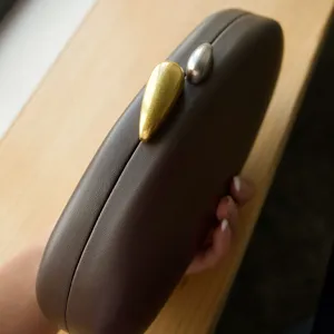 Brown matte hard case evening clutch bag with unique gold and silver teardrop metal clasps.