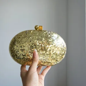 Gold glitter acrylic oval clutch bag detail view, shimmering evening party handbag display.