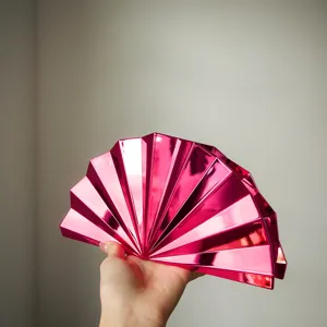 Detailansicht der metallisch rosa plissierten Fächer-Clutch mit einzigartiger Geometrie.