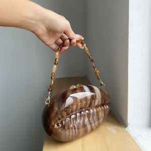 Detailed view of the brown gradient acrylic shell evening bag with a matching beaded handle.