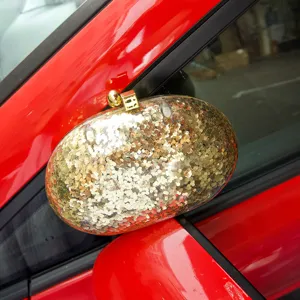 Gold glitter acrylic clutch bag detail, elegant evening party oval minaudiere purse style.