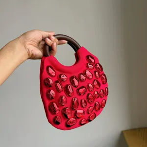 Chic red woven handbag with round wooden handle and trendy 3D pebble decorations for daily use.