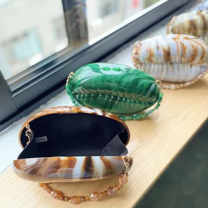 Acrylic evening bag detail showcasing smooth glossy texture, hard shell, and inner lining.