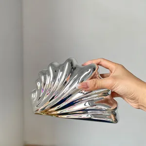 Detaillierte Ansicht der silbernen Acryl-Muscheltasche, elegante Abendtasche Textur.