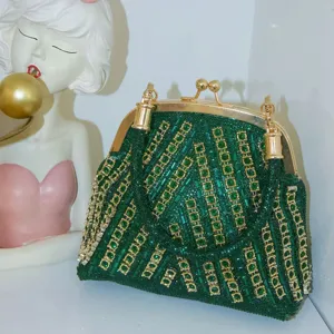 Detailed view of dark green sequined evening clutch bag with sparkling rhinestones and gold hardware.
