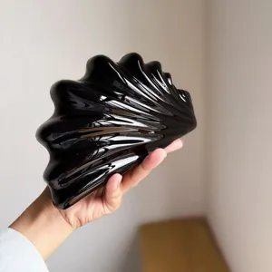 Nahaufnahme der schwarzen glänzenden schalenförmigen Acryl-Abendtasche mit einzigartiger Textur.