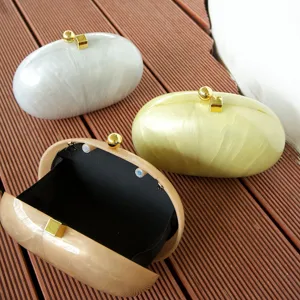 Detail view of marble acrylic shell clutch bags in multiple colors with gold tone hardware.