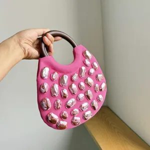 Fashion pink knit handbag featuring round wooden handle and metallic stone embellishments