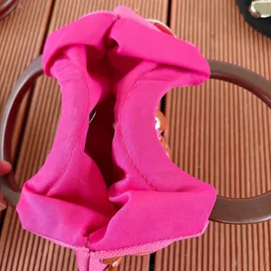 Hot pink fabric handbag interior detail showing bright color lining and brown ring handle.
