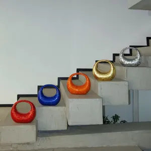 Detailed shot of trendy glitter crescent hobo handbags on stairs in multiple vibrant colors.
