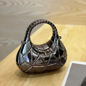 Detailansicht der metallischen Acryl Handtasche mit Mondsichel und unregelmässigen Linien.