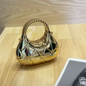 Goldene metallische Hanteltasche im geometrischen Facettendesign, trendiger Nischen-Luxusstil.