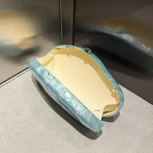 Elegant marble pattern acrylic evening clutch bag with unique irregular shape and gold hardware.