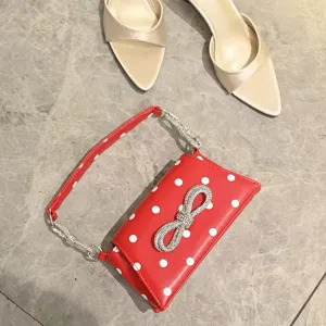 Rote Umhängetasche mit Punkten, funkelnder Strassschleife und schickem Kristallriemen für Damen.