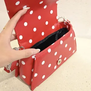 Rote weiße Punkte Handtasche Detail, zeigt den praktischen Klappverschluss und Kette.