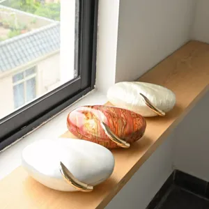 Acryl Mango Clutch Tasche Detailansicht, Kiesel-Hartschalenbox mit goldenem Klauengriff.