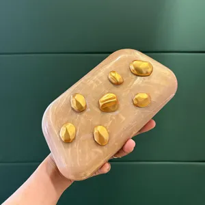 Acryl Clutch Detailansicht, einzigartiges goldenes Bohnen-Relief, stilvolles Accessoire nah