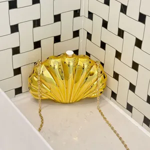 Gold acrylic shell evening clutch bag detail view, stylish minimalist crossbody chain bag.