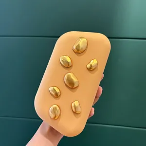 Nahaufnahme der stilvollen matten Acryl-Clutch mit einzigartigem glänzenden Goldsteindekor.