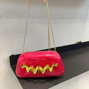 Rosa Marmor Acryl Clutch Tasche mit goldenem Metallic Wellenmuster und Kette Detail.