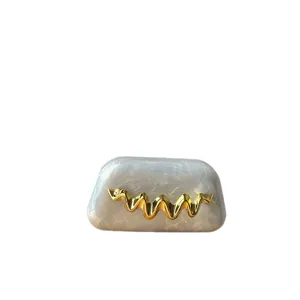 Schicke Acryl Abendtasche mit Marmormuster und goldenem Wellen Design für Frauen.