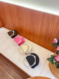 Close-up view of elegant evening handbags featuring sparkling crystal circle handles and vibrant colors.