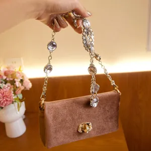 Fluwelen schoudertas met luxe strassketting, elegant modeaccessoire perfect voor feestelijke avond.