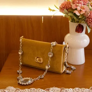 Gedetailleerd overzicht van de elegante fluwelen avondtas met sprankelende strass ketting.