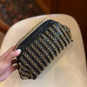 Elegant black rhinestone evening bag with gold geometric accents for chic party wear and weddings.