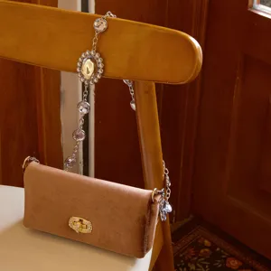 Detail van de bruine fluwelen avondtas met sprankelende strass ketting en mooie sluiting.