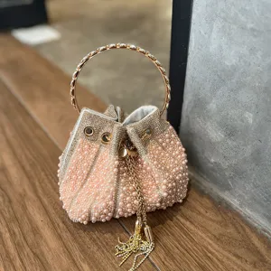 Primer plano del elegante bolso de cubo de perlas que destaca pedrería y detalles finos.