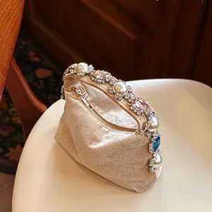 Detalle en primer plano del lujoso bolso de noche de terciopelo con perlas y pedrería.