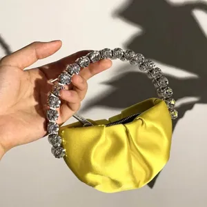 Yellow satin pleated mini handbag with statement rhinestone ring handle for evening parties.