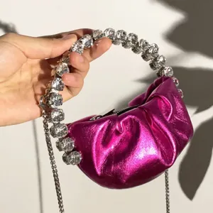 Metallic pink ruched mini handbag featuring a glamorous crystal rhinestone ring handle.